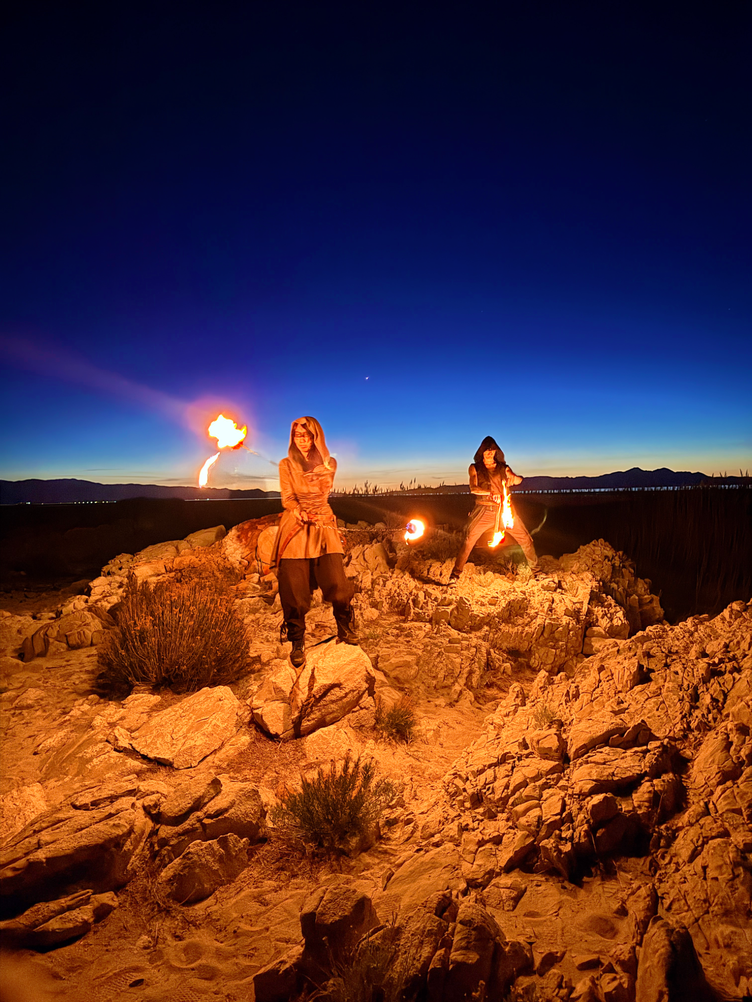 Two performers with fire at blue hour